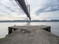 a view of the bay under a bridge from a pier in front of the ocean