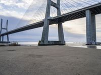 a view from under of the bridge from below in the sand with people below and people below