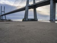 a view from under of the bridge from below in the sand with people below and people below