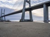 a view from under of the bridge from below in the sand with people below and people below