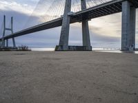 a view from under of the bridge from below in the sand with people below and people below