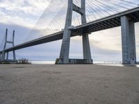 a view from under of the bridge from below in the sand with people below and people below