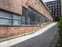 the red brick road that goes up to the bottom of the building leads into a long narrow path