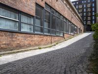 the red brick road that goes up to the bottom of the building leads into a long narrow path