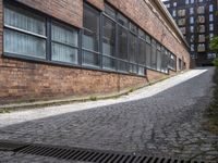 the red brick road that goes up to the bottom of the building leads into a long narrow path