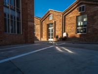 the shadow of a person walking past brick buildings in the sunlight near a bicycle lane