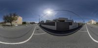 a fish - eye view of a building in the road from the intersection with street cars