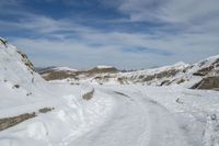 an image of a path in the snow with a sky and clouds in the background