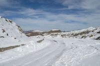 an image of a path in the snow with a sky and clouds in the background