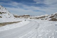 an image of a path in the snow with a sky and clouds in the background