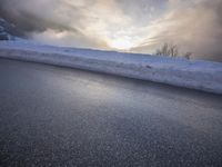 a car drives on a road in the mountains in winter weather and snow in the foreground