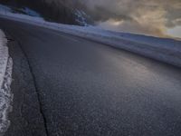 a car drives on a road in the mountains in winter weather and snow in the foreground