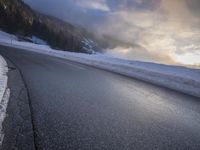 a car drives on a road in the mountains in winter weather and snow in the foreground