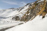 a person on a snow board rides down the slope on a snowy mountain with a mountain