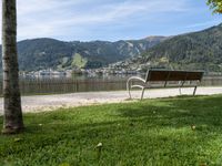 a bench is next to a road that has a view of mountains in the background