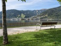 a bench is next to a road that has a view of mountains in the background