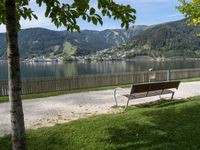 a bench is next to a road that has a view of mountains in the background