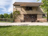 a house that has a fence around it that is empty and is in a grassy field