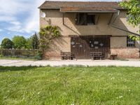 a house that has a fence around it that is empty and is in a grassy field