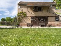 a house that has a fence around it that is empty and is in a grassy field