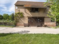 a house that has a fence around it that is empty and is in a grassy field