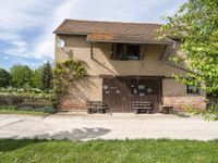 a house that has a fence around it that is empty and is in a grassy field