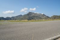 a motorcycle parked on the side of the road in a mountainous area, looking toward mountains