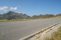 a motorcycle parked on the side of the road in a mountainous area, looking toward mountains