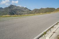 a motorcycle parked on the side of the road in a mountainous area, looking toward mountains