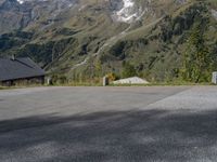 the back end of a motorcycle traveling down the road in a mountainous area with snowy mountains