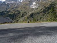 the back end of a motorcycle traveling down the road in a mountainous area with snowy mountains