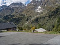 the back end of a motorcycle traveling down the road in a mountainous area with snowy mountains