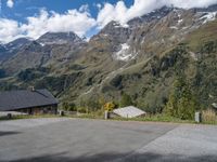 the back end of a motorcycle traveling down the road in a mountainous area with snowy mountains