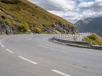 a man on a motorcycle rides down a mountain side road to get to another bike