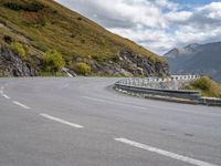 a man on a motorcycle rides down a mountain side road to get to another bike