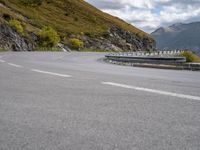 a man on a motorcycle rides down a mountain side road to get to another bike