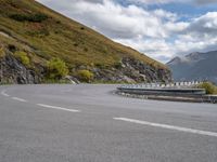 a man on a motorcycle rides down a mountain side road to get to another bike