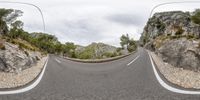 a road passing through an upside down rocky slope with two mirrors in the corner to show off the camera's lens