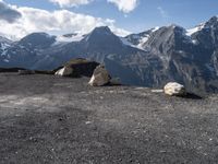 rocky ground with large stones on the top and snow covered mountain in background on sunny day