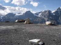 rocky ground with large stones on the top and snow covered mountain in background on sunny day