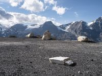 rocky ground with large stones on the top and snow covered mountain in background on sunny day