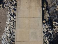 a street sign next to a wall made of rocks and stones for construction near the water