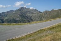 a lone motorcycle rider is riding down a long stretch of road through the mountains that stretches into the valley