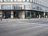 a city street that is mostly paved with concrete and sidewalking, and bicycles parked on it