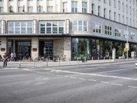 a city street that is mostly paved with concrete and sidewalking, and bicycles parked on it