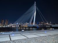 a white bridge with some lights and a city in the background with the lights on