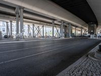 the view of the city under a highway with bikes parked on it, on the road side and on the street