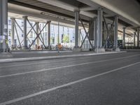 the view of the city under a highway with bikes parked on it, on the road side and on the street