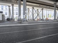 the view of the city under a highway with bikes parked on it, on the road side and on the street