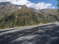 the road has no cars along the sides of the mountains on either side is a highway